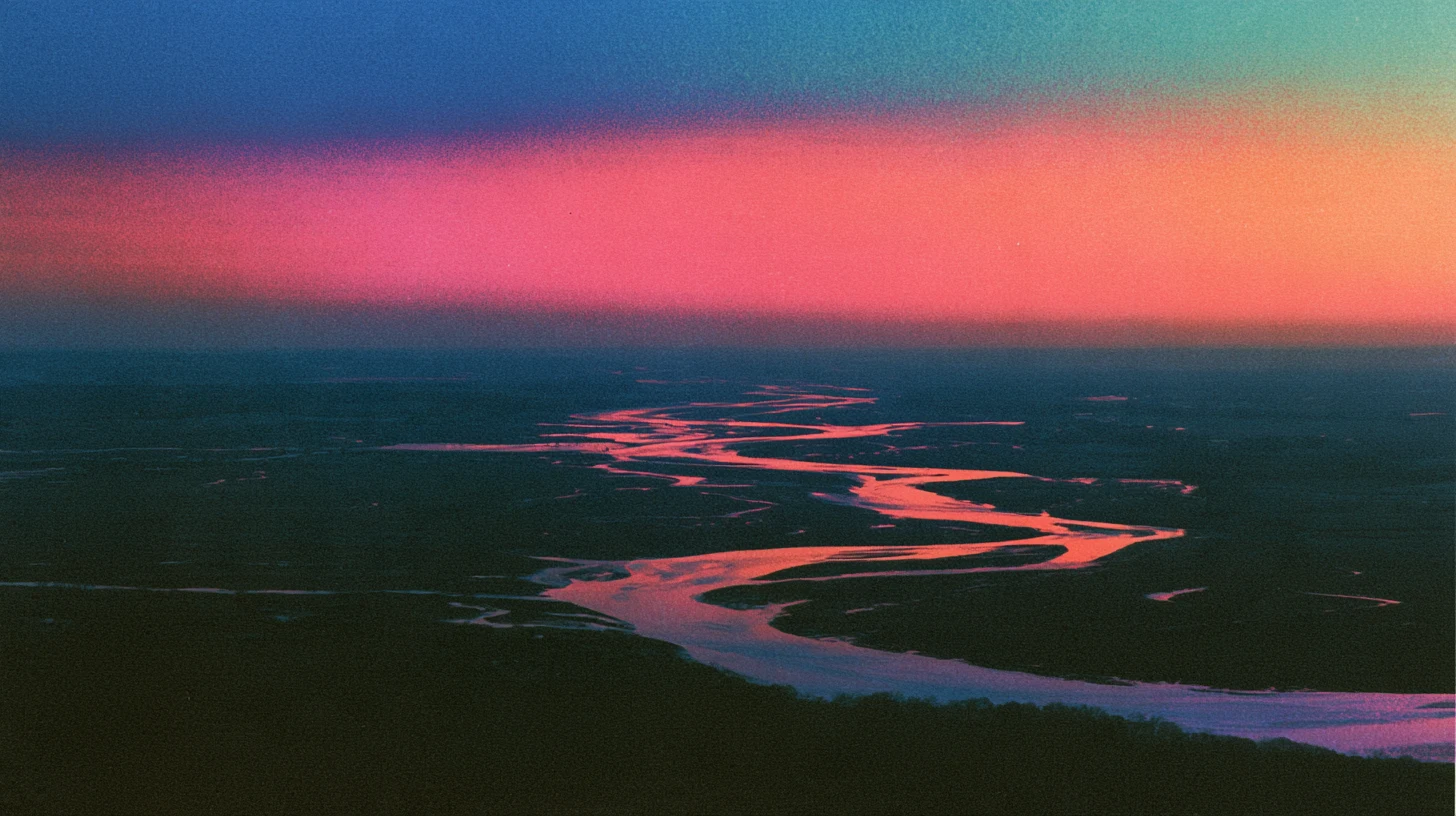 A river branching into many channels across a plain at dusk, in grainy color.